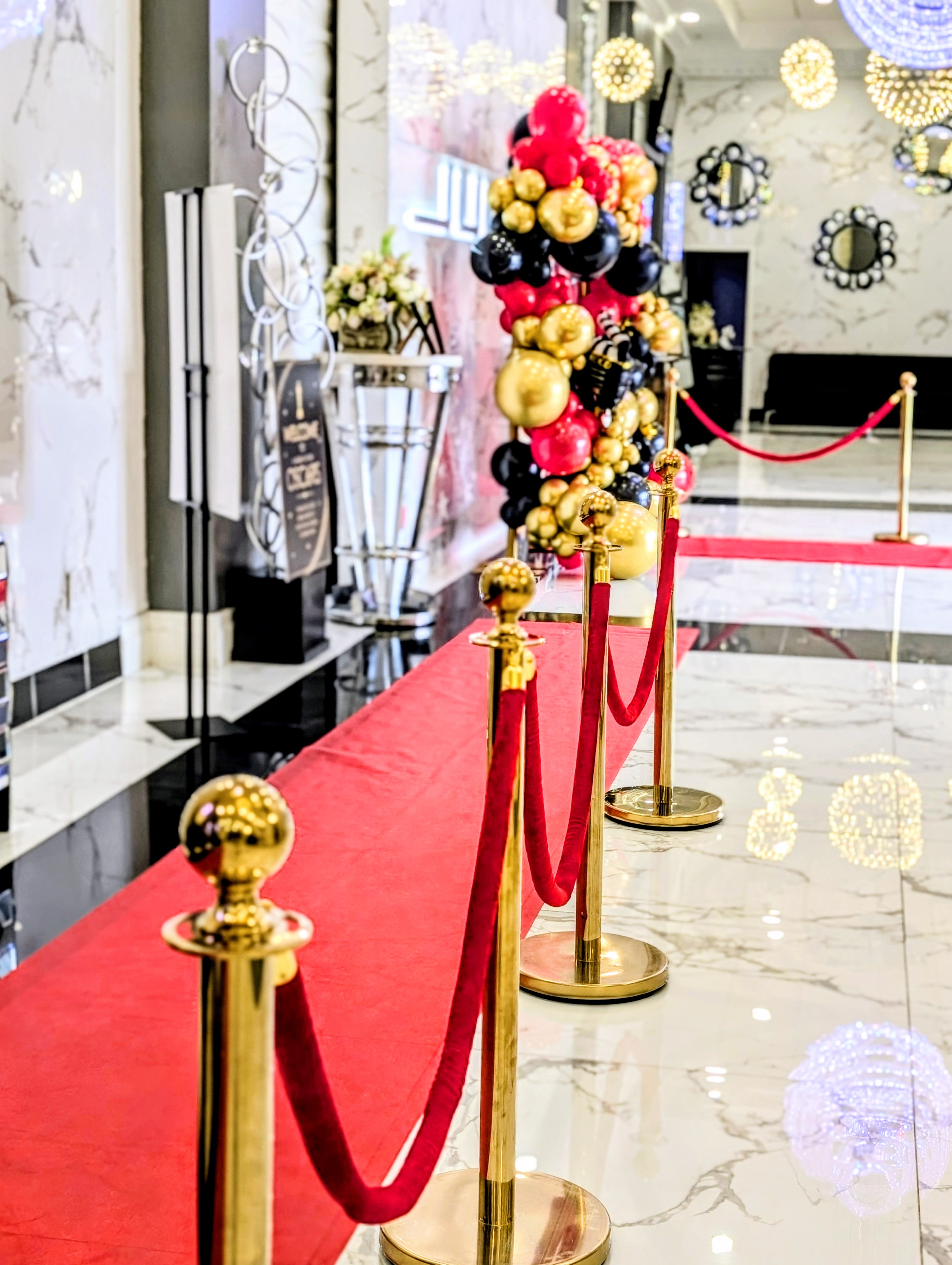 Red-carpet entrance with gold stanchions and red velvet ropes