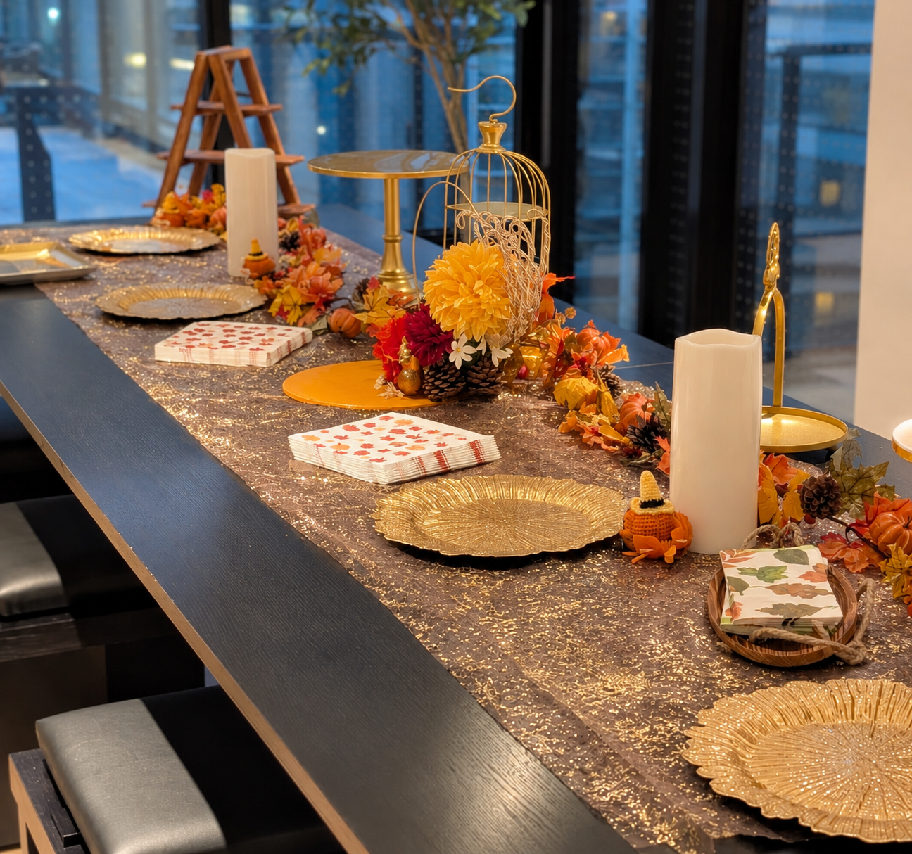 Thanksgiving table with gold plates, candles and autumn florals
